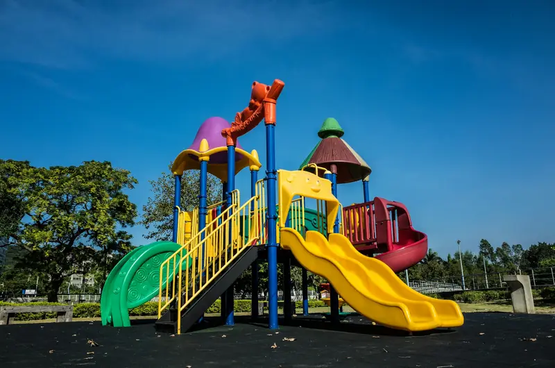 Bunter Spielplatz mit Rutschen und Klettergerüst